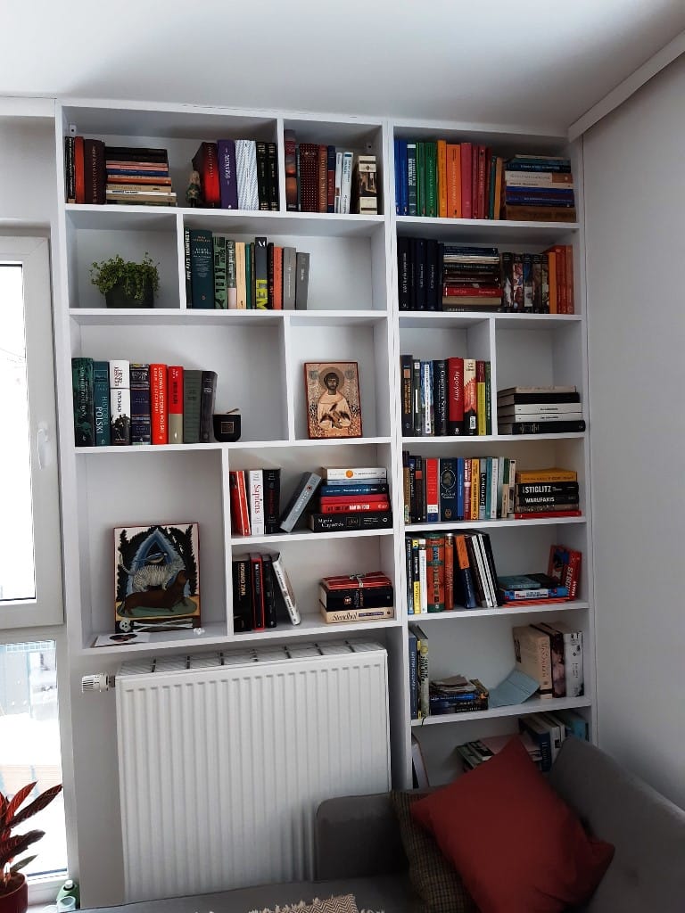 Regał na książki wykonany z białego laminatu.